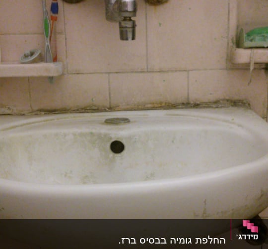 כיור עם ברז חלוד וצנרת מתחת